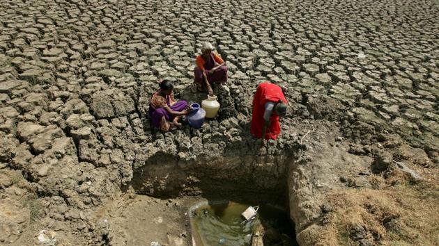 Women fetch water from an opening made by residents at a dried-up lake in Chennai, Tamil Nadu. (P. Ravikumar / REUTERS)