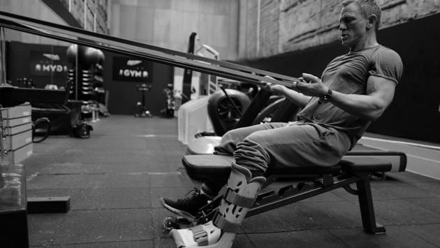 Daniel Craig working out with a cast on his leg.