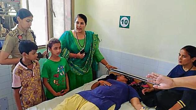 Member of Women’s Commission Kiranpreet Kaur Dhami with the victim at a hospital in Muktsar on Saturday.(HT)