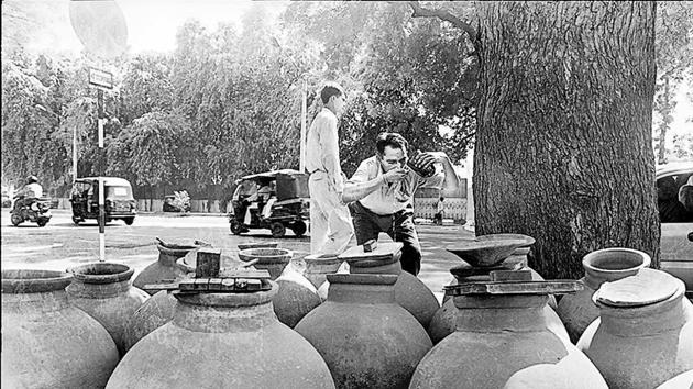 A man quenches his thirst from a pitcher by the roadside. Such pitchers were a common sight across Delhi until the 1990s.(Subhendu Ghosh/ HT Archives)