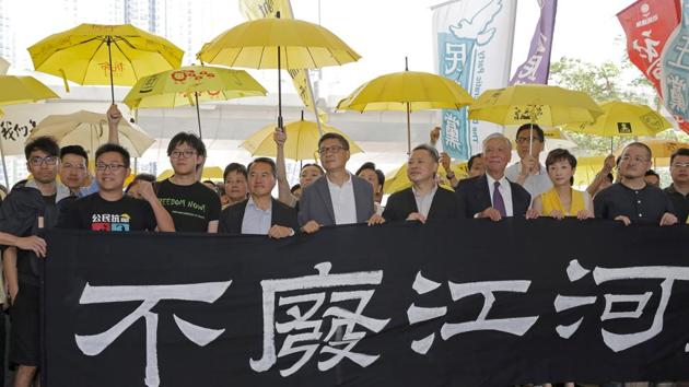 April 2019: A Hong Kong court convicted nine leaders of the 2014 pro-democracy demonstrations known as the “Umbrella Movement.” Hong Kong judges were reportedly under pressure from China to hand down heavy sentences to deter future protests. Occupy Central leaders hold a banner before entering a court in Hong Kong on April 24, 2019. The banner partially seen reads: “The flow of the river is never changed.” (Kin Cheung / AP)