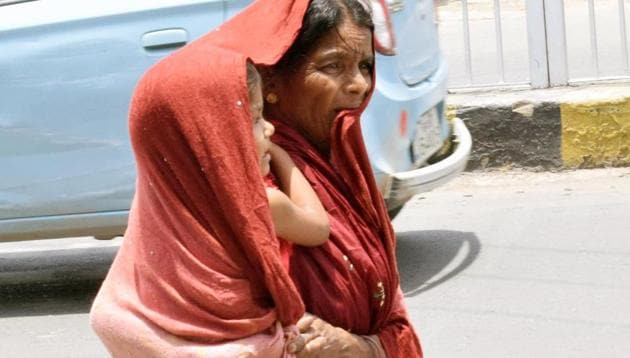 A woman covers herself and her child in Patna on Saturday which was the hottest in the city in ten years.(Santosh Kumar//HT PHOTO)
