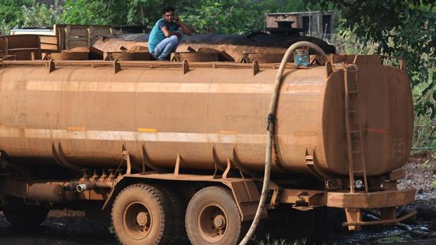 A driver waits for the tanker to fill up with water. Dukre will keep delivering water until the monsoon is in full swing in Maharashtra, likely by the end of the month. Every night he and his colleagues sleep in their vehicles on wasteland beside a river where the tankers are lined up. (Punit Paranjpe / AFP)