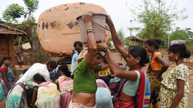A woman assists an elderly person in carrying a bucket filled with tanker water at Shakar Pada village near Shahapur, on the outskirts of Mumbai. As Gajanand Dukre (not pictured) parks his water tanker in this drought-stricken Indian village, dozens of locals -- mostly women -- come streaming with jerry cans, buckets and stainless steel pots. (Punit Paranjpe / AFP)