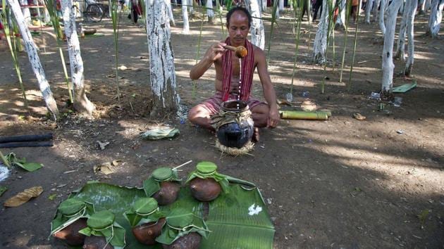 A Rabha priest makes the traditional rice beer. Then the community gathers near the house of the head priest and sings ritual songs while drinking and dancing. Worship begins the next day. A man from each household and village priests go to designated worship places in the jungles, pray and sacrifice animals. After the ceremonies, men share more cold rice beer. (Anupam Nath / AP)