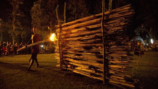 Priests cover their bodies and faces with rice powder. They burn a “mejhi,” a wall of bamboo filled with festive food and plant debris. Fire and the beating of drums create an atmosphere and are believed to protect villages from evil spirits by energizing the air. (Anupam Nath / AP)