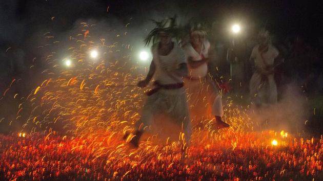 The flames and sounds are also seen as the source of adrenaline for holy leaders who run barefoot over hot coals. Afterwards, village women wash the priests’ feet and serve them refreshments to honour their bravery. (Anupam Nath / AP)