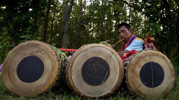 A man practices before performing a cultural dance with traditional drums during Baikho festival After sunset, spiritual leaders visit each household, sing ceremonial songs and sprinkle rice on the rooftops. They are offered rice beer. (Anupam Nath / AP)