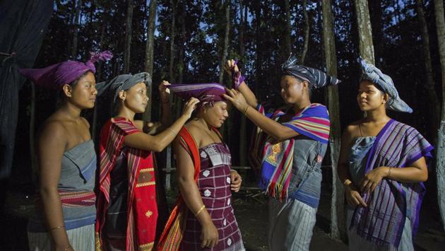 Rabha tribal girls adjust their traditional head gear during Baikho festival. The festival lasts between three and seven days. Traditional music and the locally brewed local rice beer are both in abundance. (Anupam Nath / AP)