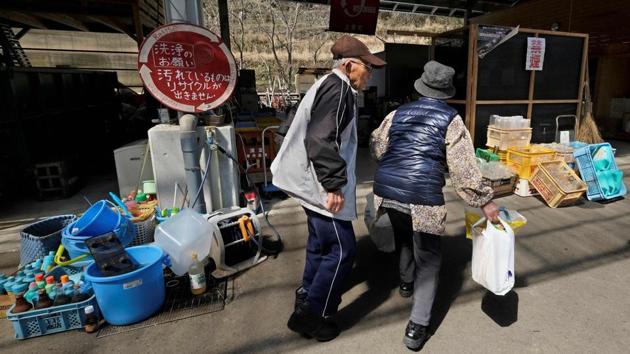 An elderly couple brings in trash. Kazuyuki Kiyohara said plastic makes up the majority of the residents’ waste -- and despite the scheme there has been little reduction in consumption. “Our lifestyle depends mainly on plastic,” the 38-year-old said, adding: “Consumers can reduce plastic waste to a certain extent, but we’ll still have waste if producers keep making plastic products.” (Kazuhiro Nogi / AFP) 