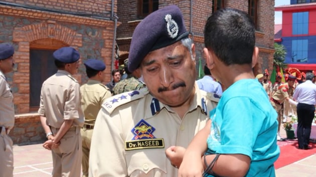 Srinagar senior superintendent of police Haseeb Mughal held the son of Arshad Khan, who was killed in a militant attack, in his arms during the wreath-laying ceremony.(Twitter / J&K Police) Srinagar senior superintendent of police Haseeb Mughal held the son of Arshad Khan, who was killed in a militant attack, in his arms during the wreath-laying ceremony.(Twitter / J&K Police)