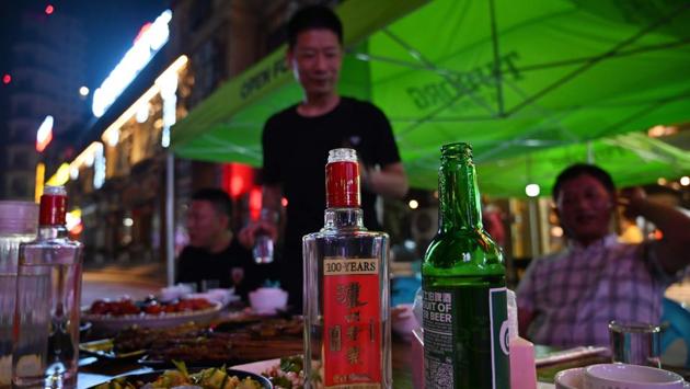 A bottle of baijiu liquor on a table while people enjoy dinner at a restaurant. Jim Boyce, a Beijing blogger on China’s booze scene who launched August 9 “World Baijiu Day” in 2015, said baijiu is hampered by how it’s consumed in China: straight up, with food. “The fact is, people, at least in North America and Europe, don’t drink lukewarm straight 52% alcohol,” he said. (Hector Retamal / AFP) A bottle of baijiu liquor on a table while people enjoy dinner at a restaurant. Jim Boyce, a Beijing blogger on China’s booze scene who launched August 9 “World Baijiu Day” in 2015, said baijiu is hampered by how it’s consumed in China: straight up, with food. “The fact is, people, at least in North America and Europe, don’t drink lukewarm straight 52% alcohol,” he said. (Hector Retamal / AFP)