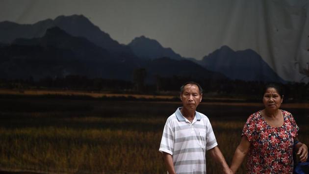 Visitors standing in front of a backdrop near the entrance of the Tham Luang cave. “A miracle has happened here with these children,” Singaporean tourist Cheong, giving one name, said but adding Tham Luang “must still have a spiritual side” despite the mass popularity. (Lilian Suwanrumpha / AFP)