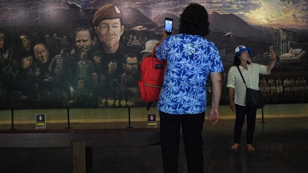 Streams of tourists explore a visitor hub where the centrepiece is a mural entitled “The Heroes”. It depicts the footballers and junta chief Prayut Chan-O-Cha -- a reminder of the governmental fingerprints in aiding their cause. At the heart of the mural is the beaming face of Saman Gunan, the Thai Navy SEAL diver who ran out off oxygen attempting to establish an air line to the team and their coach. (Lilian Suwanrumpha / AFP)