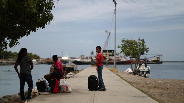 Local residents wait for a boat in a dock at Guiria. Trinidad would almost certainly have better medical care, Bastardo and Berra reckoned. An extra incentive: a child born there would be a citizen and could make it easier for them to obtain legal residency someday. Family members would accompany Bastardo to watch out for her and the little ones, 3-year-old Dylan and Victoria, 2. (Ivan Alvarado / REUTERS) Local residents wait for a boat in a dock at Guiria. Trinidad would almost certainly have better medical care, Bastardo and Berra reckoned. An extra incentive: a child born there would be a citizen and could make it easier for them to obtain legal residency someday. Family members would accompany Bastardo to watch out for her and the little ones, 3-year-old Dylan and Victoria, 2. (Ivan Alvarado / REUTERS)