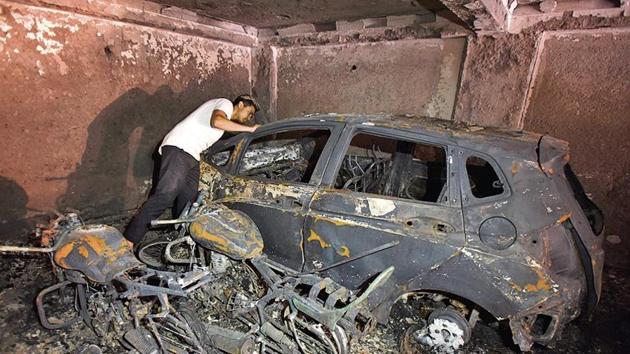 Three cars and six two-wheelers were gutted in the fire that started in the basement.(Burhaan Kinu/HT)
