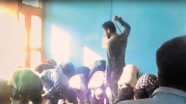 A video grab of the teacher thrashing students in a school in Doda district.(Screengrab)