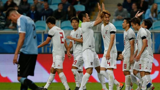 Japan's Koji Miyoshi(R) celebrates with teammates after scoring his second goal.(AFP)