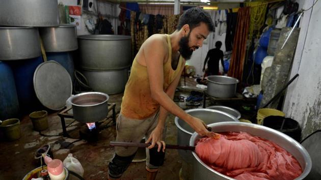 A worker in a cloth dyeing factory in Dharavi. Mumbai officials first tried to redevelop Dharavi two decades ago. Several attempts failed due to the difficulty of moving vast numbers of slum dwellers who depend on informal work to survive. The state government is trying again and recently put the redevelopment out to tender. A Dubai-based developer backed by royal families emerged as the highest bidder. (Punit Paranjpe / AFP)