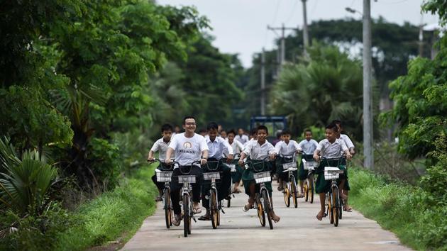 The 11-year-old is among the first 200 students to receive bicycles as part of “Lesswalk”, the brainchild of Mandalay entrepreneur Mike Than Tun Win (2n L). He grew up and was educated in Singapore before returning home eight years ago with a business degree. “I saw students walking for many hours to get to school and I felt really sorry for them,” the 33-year-old told AFP. (Ye Aung Thu / AFP)