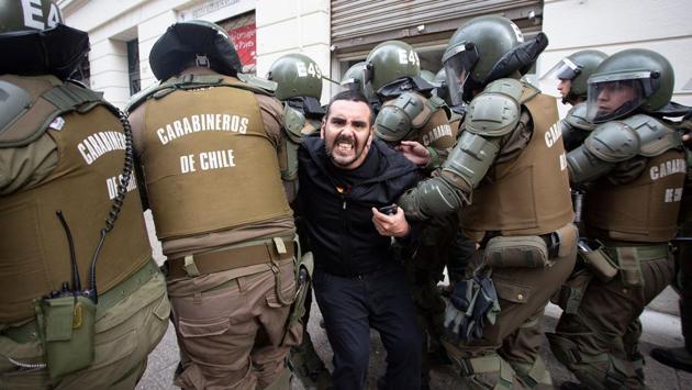 A demonstrator is detained by riot police during a teachers’ protest against a government’s plan that will be implemented in 2020 in which History and Physical Education will be optional in secondary school’s 3rd and 4th year, in Santiago, Chile. (Claudio Reyes / AFP)