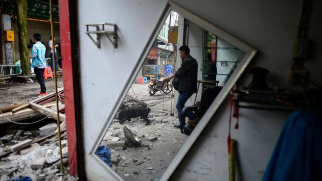 People walk past earthquake-damaged buildings in Yibin, in China’s southwestern Sichuan province. The toll from a strong 6.0-magnitude earthquake in southwest China rose to 12 dead and 134 injured on June 18, as rescuers pulled bodies and survivors from wrecked buildings. (AFP)