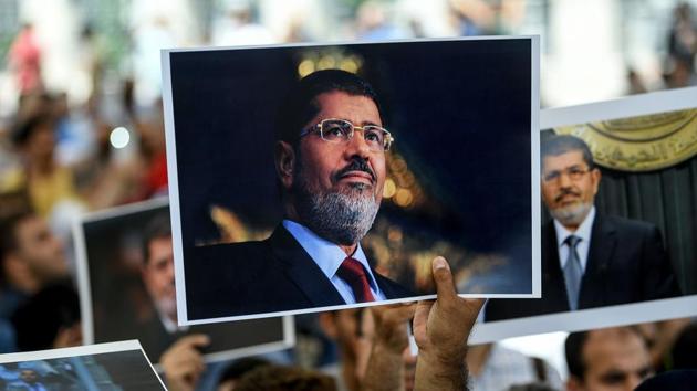 People hold picture of Egyptian President Mohamed Morsi during a symbolic funeral cerenomy at Fatih mosque in Istanbul, Turkey. Thousands joined in prayer in Istanbul for former Egyptian president Mohamed Morsi who died after collapsing during a trial hearing in a Cairo court. (AFP)