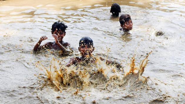 Children seen in muddy water as they beat the heat during a hot day, on a roadside, in Patna, Bihar. More than 100 people died in different parts of Bihar due to the blistering heatwave conditions in the state. (Parwaz Khan / HT Photo) Children seen in muddy water as they beat the heat during a hot day, on a roadside, in Patna, Bihar. More than 100 people died in different parts of Bihar due to the blistering heatwave conditions in the state. (Parwaz Khan / HT Photo)
