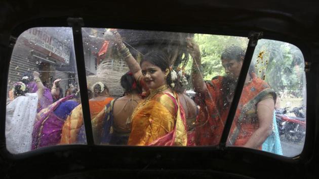 A group of married women performing rituals around a Banyan tree on the occasion of Vat Savitri festival are seen through the wind screen of a parked auto rickshaw in Mumbai, Maharashtra. Vat Savitri is celebrated on a full moon day where women pray for the longevity of their husbands. (Rafiq Maqbool / AP) A group of married women performing rituals around a Banyan tree on the occasion of Vat Savitri festival are seen through the wind screen of a parked auto rickshaw in Mumbai, Maharashtra. Vat Savitri is celebrated on a full moon day where women pray for the longevity of their husbands. (Rafiq Maqbool / AP)