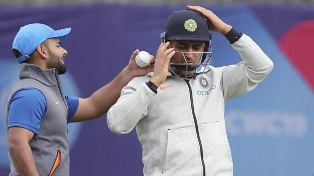 India's Rishabh Pant, left, gestures as MS Dhoni wears his helmet to bat in the nets during a training session ahead of their Cricket World Cup match against Afghanistan(AP)