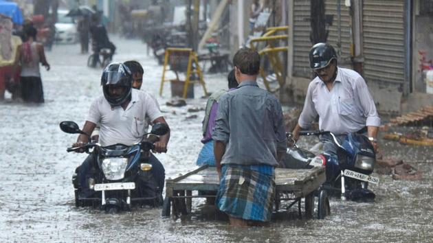 Commuters wade through a waterlogged street after pre-monsoon rain, in Patna. The weather conditions that were forecasted by the Indian Meteorological (IMD), Patna centre predicted that the city is likely to see thunderstorm with lightning today and tomorrow and receive heavy rain for two days from June 24. (PTI)