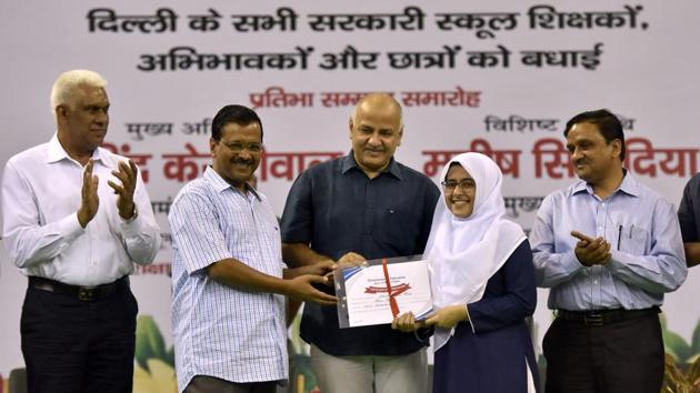 Delhi Chief Minister Arvind Kejriwal, Deputy Chief Minister Manish Sisodia, Delhi education secretary Sandeep Kumar and MLA Madan Lal present a certificate of appreciation to a student during a function celebrating the Class XII results of Delhi Government Schools, at Thyagraj Stadium in New Delhi, India on Saturday.(Sonu Mehta/HT PHOTO)