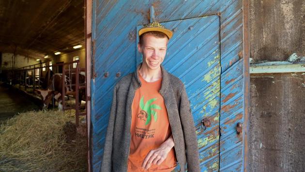 Tolik, 21, poses in front of a cowshed. Most residents are sent to live on the farm for long periods by their families or guardians and contribute towards their costs which are mostly met by charity and state donations. On the day AFP visited, art therapy teacher Irina Andreyeva was rehearsing a play with residents based on the French classic “The Little Prince” that included dance, music and their drawings. (Olga Maltseva / AFP)