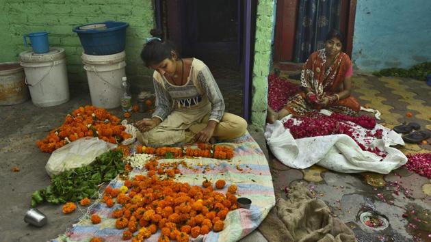 Lalita Devi (40) moved here from Bihar 15 years ago since accommodation is cheap. While her husband works as a daily wage labourer, she makes garlands. A majority of women here do so to earn a livelihood. The fragrance of roses and marigolds fills the narrow lanes on Ghat no. 28. “There are so many temples nearby. We get a contract from the sellers. They pay us Rs 10-20 for 25 garlands,” Lalita said. (Burhaan Kinu / HT Photo)