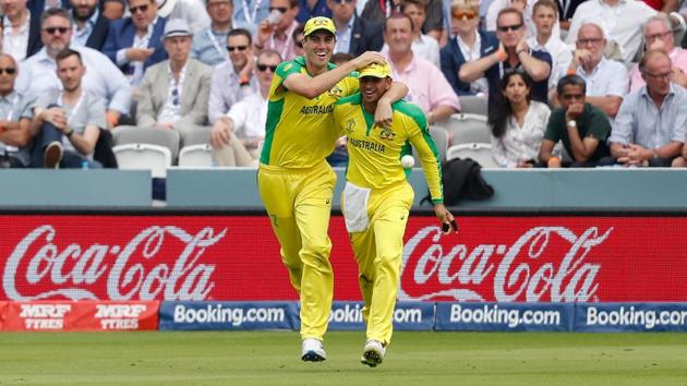Australia's Usman Khawaja (R) celebrates with teammate Pat Cummins after taking a catch to dismiss England's Jos Buttler. (AFP)