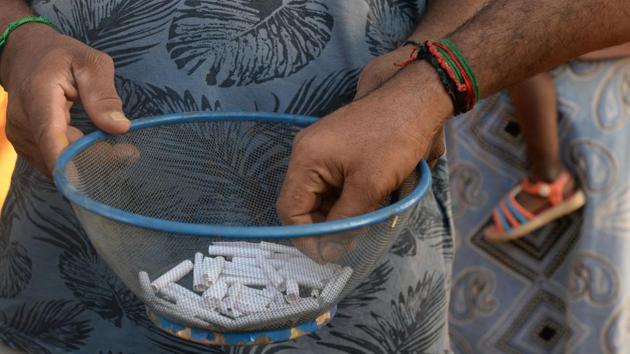 A resident picks out a numbered piece of paper as people wait for an opportunity to get water from a community well in Chennai. The 70 families who use the well are allowed three 25-litre pots each day. Most pay high prices to private companies to get the extra water they need to survive. (Arun Sankar / AFP) A resident picks out a numbered piece of paper as people wait for an opportunity to get water from a community well in Chennai. The 70 families who use the well are allowed three 25-litre pots each day. Most pay high prices to private companies to get the extra water they need to survive. (Arun Sankar / AFP)