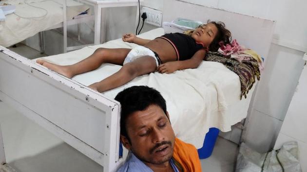 A man sleeps next to his daughter who is suffering from acute encephalitis syndrome at a hospital in Muzaffarpur, Bihar, June 20, 2019.(REUTERS) A man sleeps next to his daughter who is suffering from acute encephalitis syndrome at a hospital in Muzaffarpur, Bihar, June 20, 2019.(REUTERS)