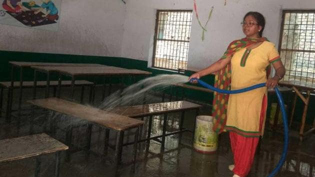 A teacher in primary school (boys) in North Vijay Nagar Colony, Agra, cleaning a classroom on Wednesday, June 26, 2019.(HT Photo)
