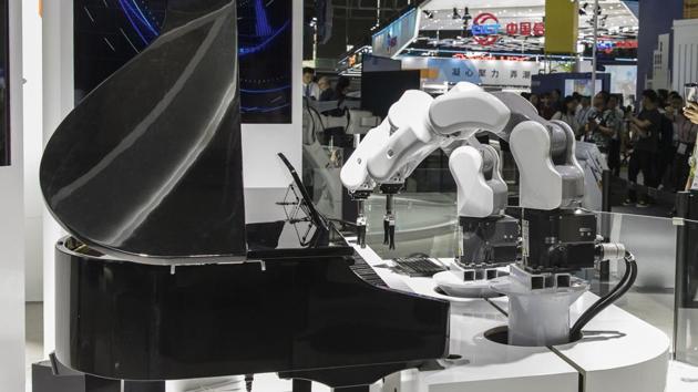 Attendees watch a demonstration performed by robotic arms at the MWC Shanghai exhibition in Shanghai, China.(Bloomberg)