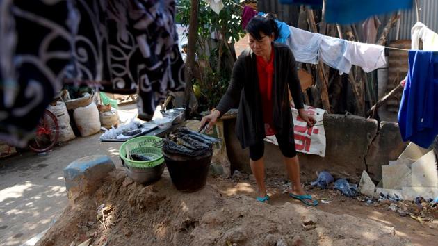 Ma Nith confessed she was “speechless” when she realised that Smor San cemetery in the capital was to be home after her arranged marriage. “It was beyond my belief that I could live here,” said the 42-year-old mother of four, flipping fillets on the grill as her son clambered over a grave. “But now, I’ve adapted to it,” she told AFP, revealing that she had lived in the graveyard for 16 years. (Tang Chhin Sothy / AFP)