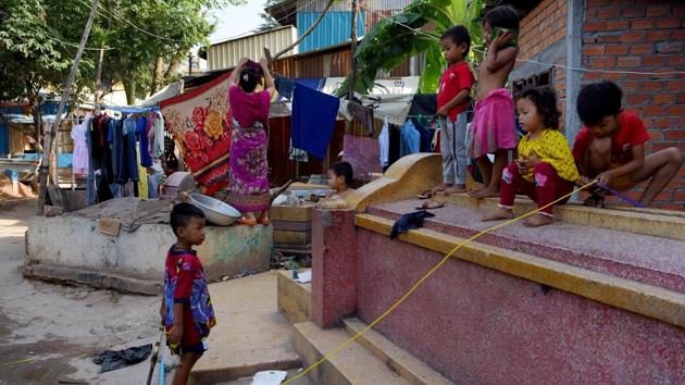 Children play on a grave as a woman dries her clothes on another. “They say it’s messy because a lot of people live here,” said Peanh Moeun seated on a wooden bed by a gravestone while children rooted around strewn garbage scavenging for resellable scrap metal. “They would unearth their ancestors to bury them in another place,” the 63-year-old added. (Tang Chhin Sothy / AFP)