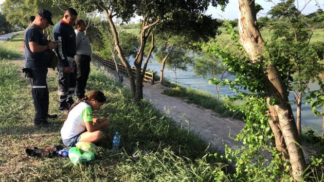 Exasperated by the wait to apply for asylum, Martinez and Angie Valeria attempted to swim to US soil on Sunday, an immigration official in the Mexican state of Tamaulipas said. Tania Vanessa Avalos, Oscar’s wife (sitting), survived, screaming “Where is my husband?” as rescue workers at the river bank carried away a stretcher covered with a white sheet, video images show. (Alejandro Hernandez / Expreso de Matamoros via REUTERS)