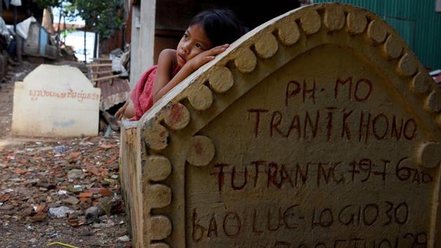 A girl lying on a grave in Phnom Penh, Cambodia. Graveyards may traditionally be the eternal resting place for the dead, but one cemetery in Phnom Penh is increasingly becoming a place to stay for the living as land disputes plague the nation’s poor. (Tang Chhin Sothy / AFP) A girl lying on a grave in Phnom Penh, Cambodia. Graveyards may traditionally be the eternal resting place for the dead, but one cemetery in Phnom Penh is increasingly becoming a place to stay for the living as land disputes plague the nation’s poor. (Tang Chhin Sothy / AFP)