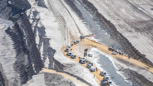 Policemen secure a driveway of the Garzweiler brown coal mine in Garzweiler, Germany, where climate activists entered the grounds, during a weekend of massive protests in a growing “climate civil disobedience” movement. (Marcel Kusch / dpa / AFP) Policemen secure a driveway of the Garzweiler brown coal mine in Garzweiler, Germany, where climate activists entered the grounds, during a weekend of massive protests in a growing “climate civil disobedience” movement. (Marcel Kusch / dpa / AFP)