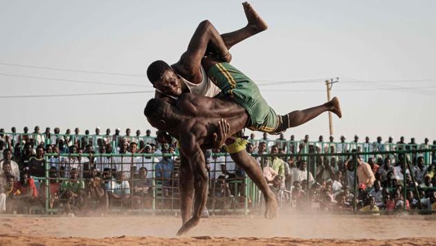 Sudanese wrestlers fight during a traditional Nuba wrestling match at the Haj Youssef stadium in the district of Khartoum, Sudan. Originating in the Nuba mountains, the sport has become wildly popular country-wide in recent years. The Sudanese Nuba wrestling federation organizes matches every Friday that attract hundreds of people. (Yasuyoshi Chiba / AFP) Sudanese wrestlers fight during a traditional Nuba wrestling match at the Haj Youssef stadium in the district of Khartoum, Sudan. Originating in the Nuba mountains, the sport has become wildly popular country-wide in recent years. The Sudanese Nuba wrestling federation organizes matches every Friday that attract hundreds of people. (Yasuyoshi Chiba / AFP)
