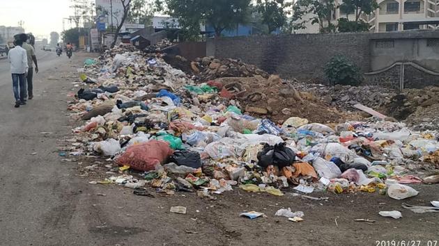 People walk besides piles of garbage dumped on Bakore chowk in Wagholi. (HT PHOTO) People walk besides piles of garbage dumped on Bakore chowk in Wagholi. (HT PHOTO)