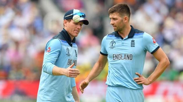 England's captain Eoin Morgan (L) speaks with teammate England's Mark Wood during the 2019 Cricket World Cup group stage match between England and Australia at Lord's Cricket Ground in London on June 25, 2019.(AFP)