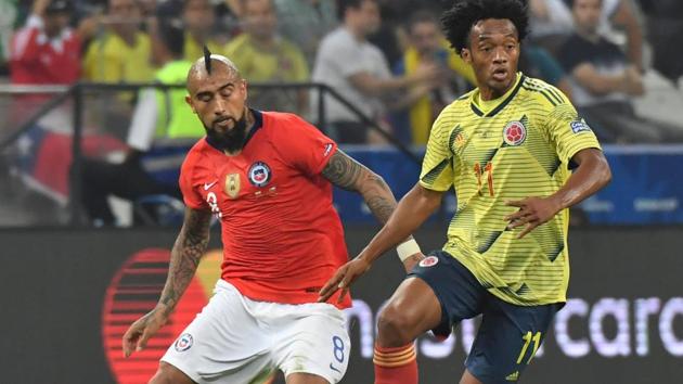 Colombia's Juan Guillermo Cuadrado (R) is marked by Chile's Arturo Vidal during their Copa America football tournament.(AFP)