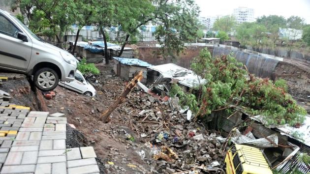 The 15-feet-high compound wall of the housing complex in Kondhwa area of Pune toppled over on Friday night and buried a cluster of adjoining tin-roofed shanties that housed migrant workers from Bihar and their families.(HT photo)