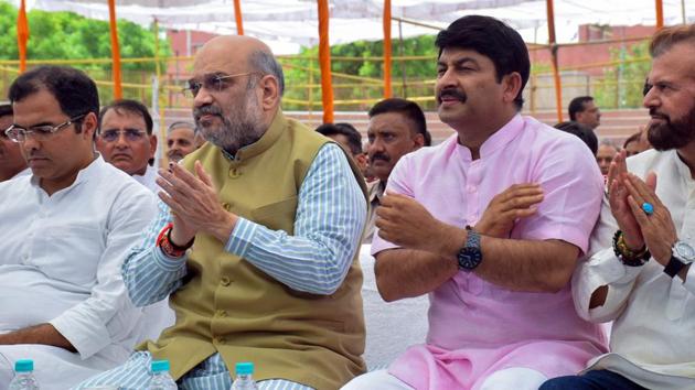 Union Home Minister Amit Shah along with Delhi BJP President Manoj Tiwari, MPs Hans Raj Hans and Parvesh Verma listen to Prime Minister Narendra Modi's radio show 'Man Ki Baat' at Dr Sahib Singh Verma Stadium Kakrola in New Delhi on Sunday. (ANI Photo)